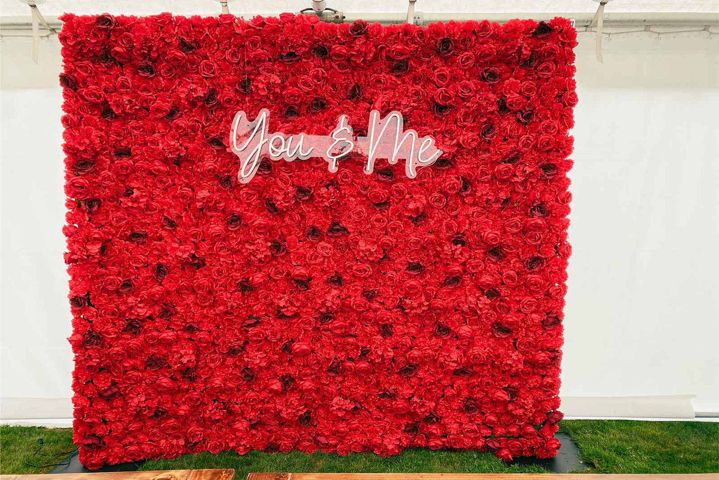 Red flower wall backdrop with “You and Me” neon sign for weddings, engagements, and couple celebrations in Auckland NZ