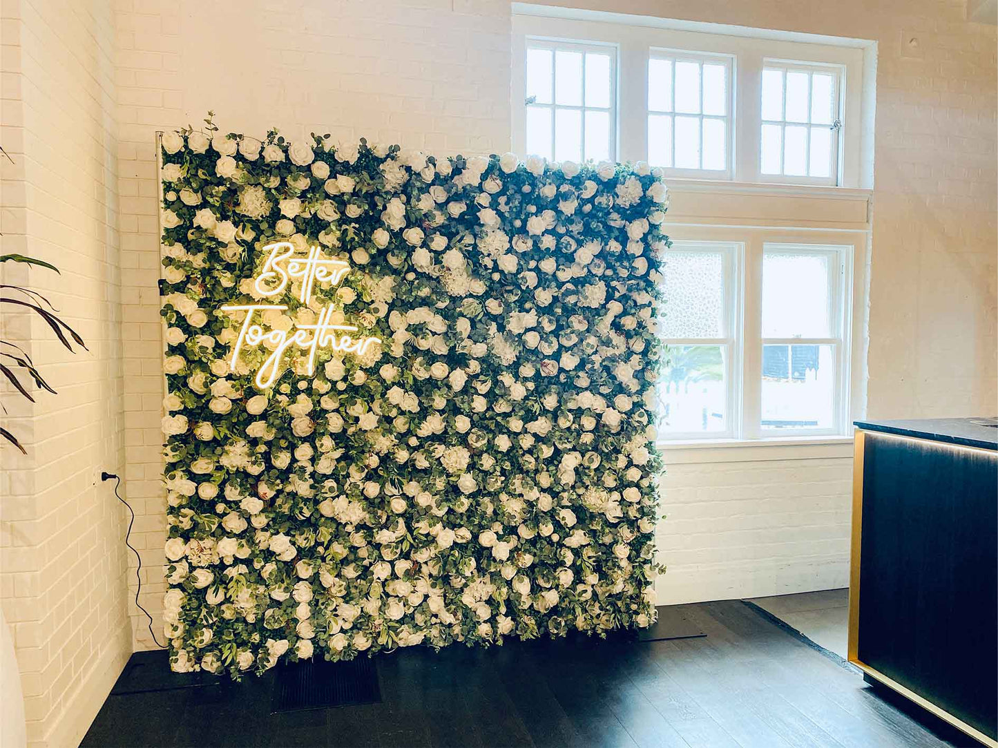 Romantic wedding flower wall with custom "Better Together" neon sign for photos