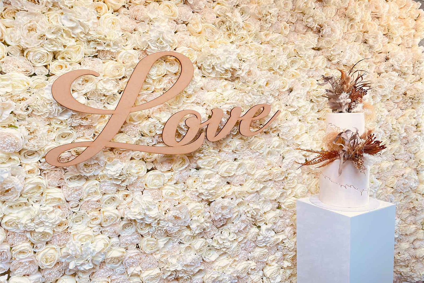 Wedding photo wall backdrop with white florals and soft texture